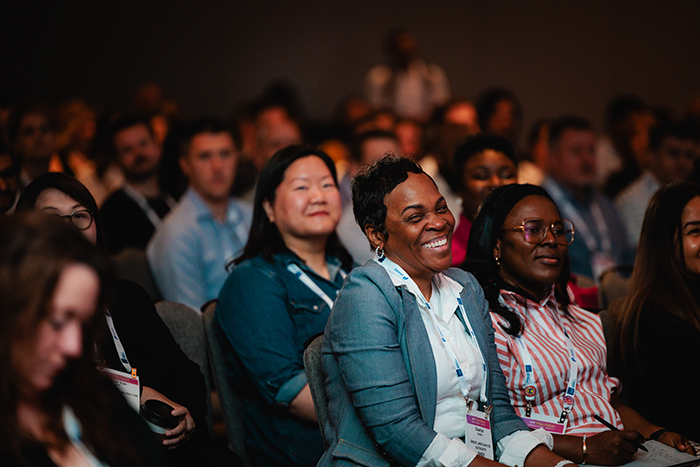 Woman laughs during a keynote speaker's presentation at the FP&A Forum Conference